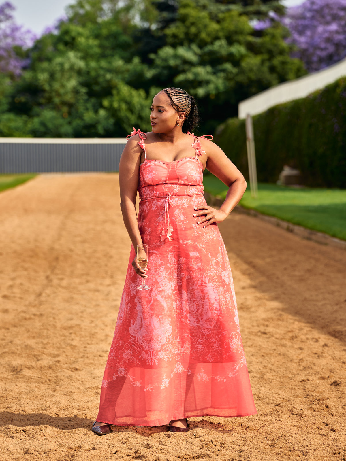 Woman in a coral floral maxi dress on the sand track
