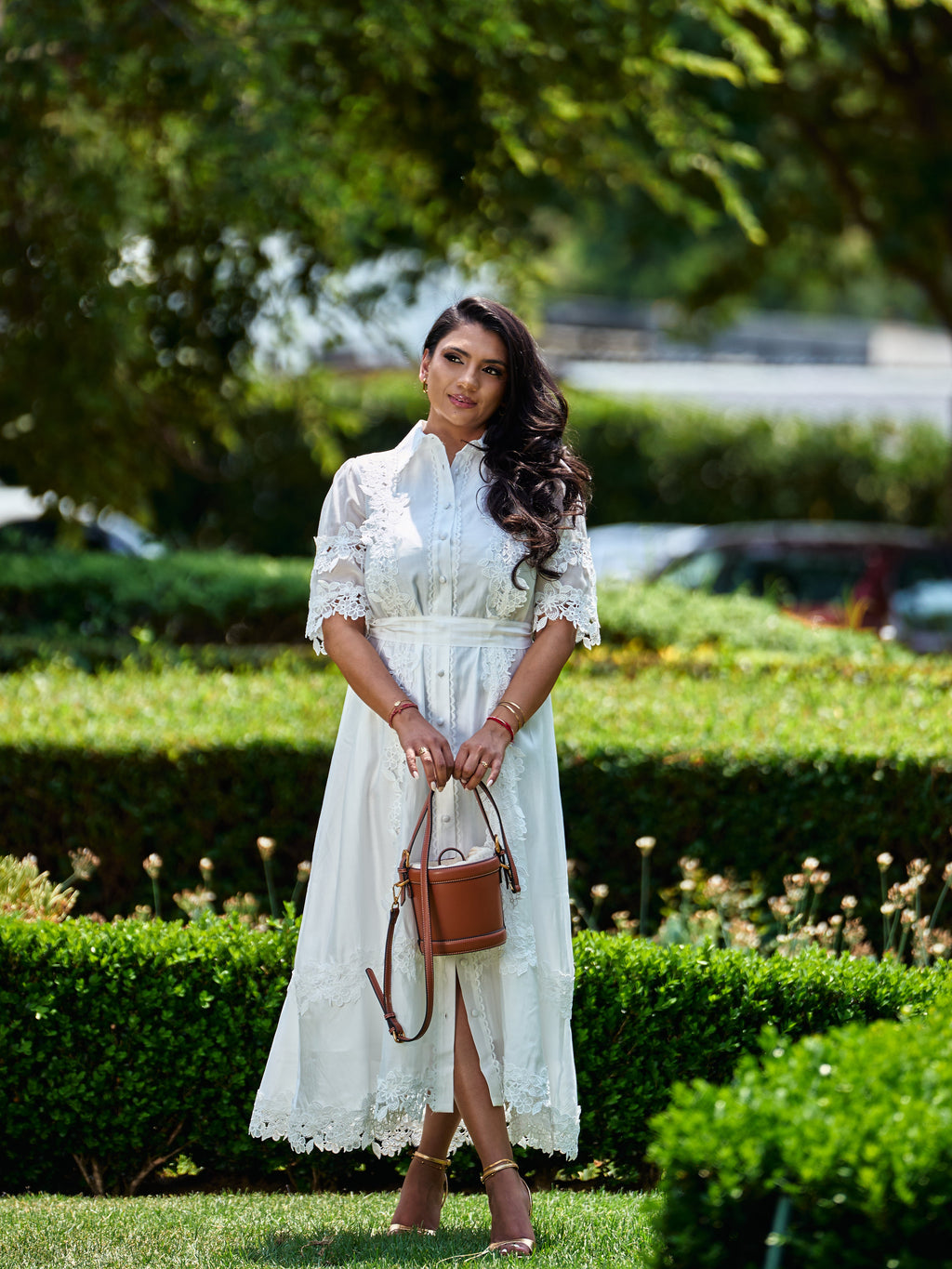 White lace shirt dress with a tan bucket bag