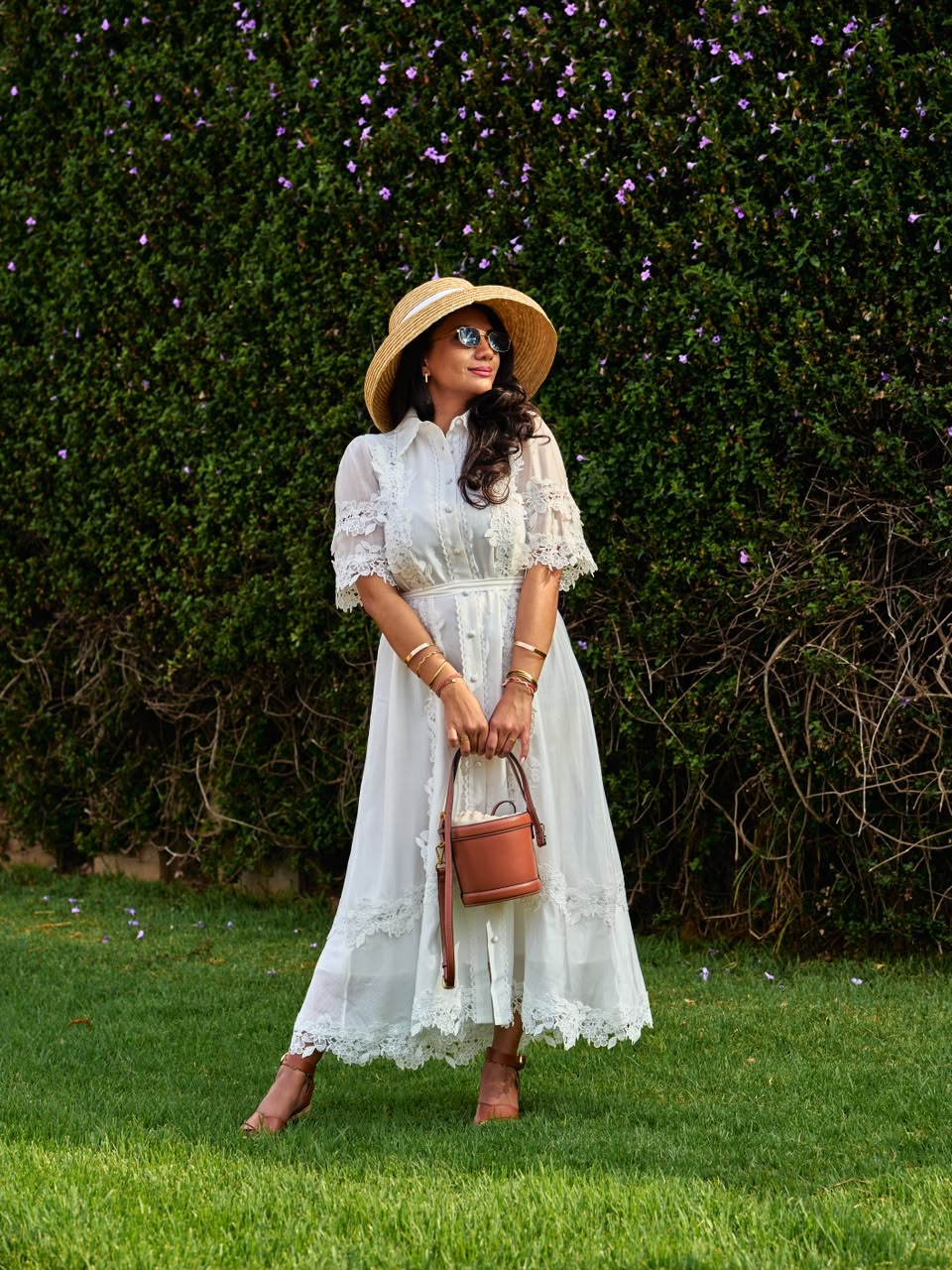 Woman in a white lace shirt dress with a straw hat