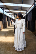 Woman in a white embellished lace gown with a beaded jacket